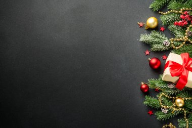 Siyah Noel arka planında yatıyordu. Şimdiki kutulu tatil süslemeleri ve siyahlı noel ağacı ve kopya alanı.