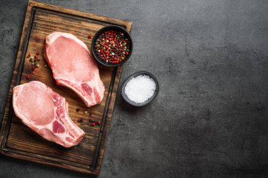 Kesme tahtasında çiğ domuz eti bifteği. Kopyalama alanı olan düz.