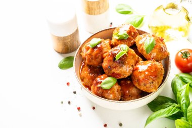 Domates soslu köfteler, beyaz masadaki servis tabağında köfteler..