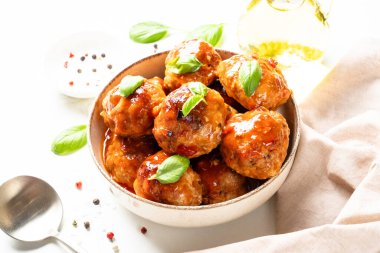 Beyaz masanın üstünde domates soslu köfte. Metin için boşluk ile kapat.