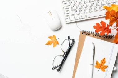 Sonbahar çalışma alanı. Laptop, defter, gözlük ve dökülen yapraklar. Metin için alanı olan düz resim.