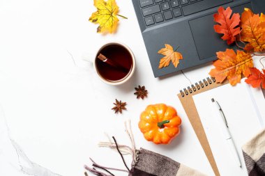 Sonbahar çalışma alanı, sonbahar dekorlu ofis masası. Laptop, defter, bir fincan çay ve dökülen yapraklar. Metin için alanı olan düz resim.