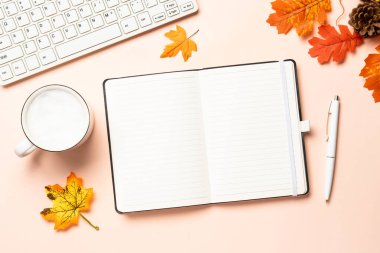 Sonbahar ofis masası. Laptop, defter, bir fincan kahve ve sarı yapraklar. Metin için boşluk ile düz uzandı.