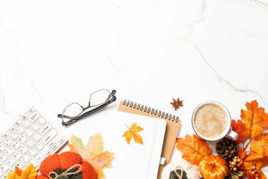 Sonbahar ofis masası. Dizüstü bilgisayar, defter, bir fincan kahve ve balkabaklı sarı yapraklar. Metin için boşluk ile düz uzandı.