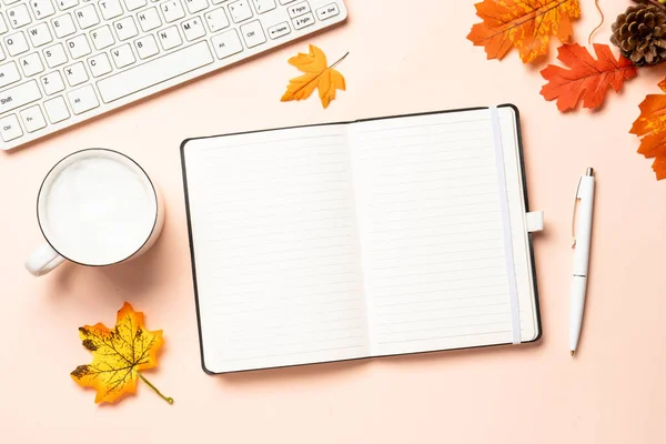 Sonbahar ofis masası. Laptop, defter, bir fincan kahve ve sarı yapraklar. Metin için boşluk ile düz uzandı.