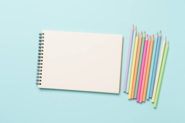 Çizim defteri ya da çizim albümü ve renkli kalemler. Çizim ve yaratıcılık için aksesuarlar.