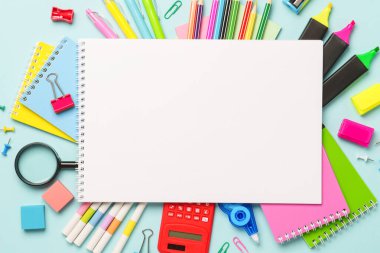 Okul gereçleri ya da mavi arka planda boş kağıtlar olan ofis kağıtları. Metin için boşluk olan üst görünüm.