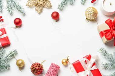 Beyaz üzerine Noel kompozisyonu. Noel kırmızı, altın madalyalar ve köknar ağacı. Kopyalama alanı olan üst görünüm.