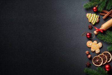 Noel yemeklerinin arka planı siyahtı. Zencefilli kurabiye, baharat ve Noel süslemeleri tasarım için uygun..