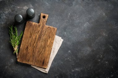 Siyah arka planda çatal bıçak ve otlarla kesme tahtası. Kopyalama alanı olan üst görünüm.