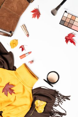 Sonbahar kumaşı ve aksesuarları. Atkı, kazak, çanta ve yapraklı kozmetik ürünler. Dizayn için alanı olan düz uzandı.