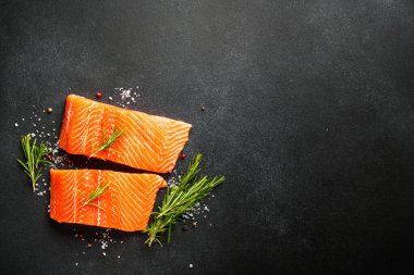 Somon balığı. Çiğ somon filetosu. Siyah arkaplanda üst görünüm.