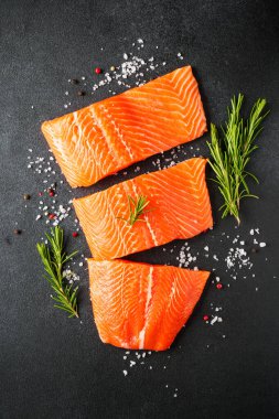 Baharatlı çiğ somon filetosu. Siyah arkaplanda üst görünüm.