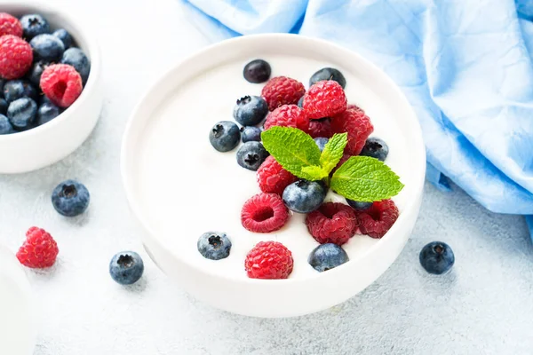 Beyaz kasede taze böğürtlen karışımı ile yoğurt. Sağlıklı atıştırmalıklar ya da kahvaltı. Diyet yemek..