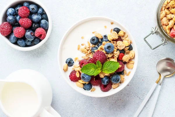 Beyaz masada taze böğürtlenli yoğurt ve tahıl gevreği. Sağlıklı kahvaltı. Üst görünüm.
