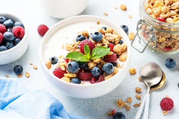 Taze böğürtlenli yoğurt ve beyaz masada granola..