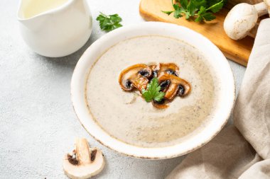 Beyaz mutfak masasında mantar çorbası püresi. Sağlıklı vejetaryen yemekleri. Kapat..