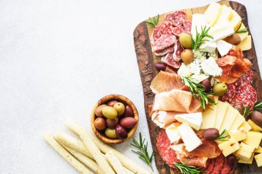 Antipasto tabağı. Peynir ve et - jamon, salam, mermer masada zeytin. Üst görünüm.