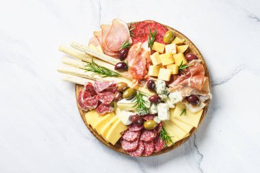 Antipasto tabağı. Tanışma ve peynir çeşitleri. Mermer masadaki en üst görünüm.