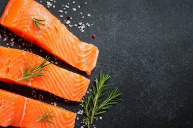 Siyah masada somon balığı. Biberiyeli çiğ somon fileto. Kopyalama alanı olan üst görünüm.