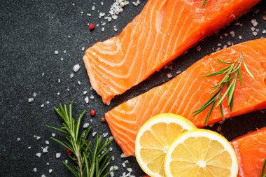 Siyah masada somon balığı. Biberiyeli çiğ somon fileto. Kopyalama alanı olan üst görünüm.