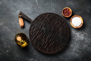 Kesme tahtası ve baharatlar siyah arka planda. Metin için boşluk ile düz uzandı.