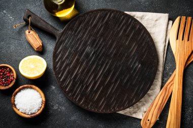 Baharat ve bitkiler, siyah arka planda kesim tahtası. Metin için boşluk ile düz uzandı.