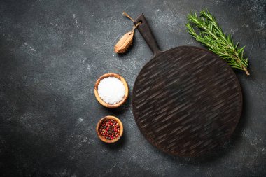Baharat ve bitkiler, siyah arka planda kesim tahtası. Metin için boşluk ile düz uzandı.