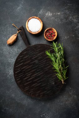 Baharat ve bitkiler, siyah arka planda kesim tahtası. Metin için boşluk ile düz uzandı.