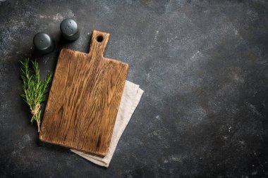 Siyah arka planda çatal bıçak ve otlarla kesme tahtası. Kopyalama alanı olan üst görünüm.