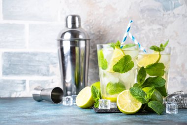 Siyah arka planda rom, nane ve limon ile mojito. Geleneksel yaz içkisi, titretici ve bar aletleriyle..