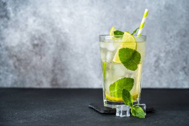 Koyu arkaplanda rom ve limonlu mojito. Buzlu alkol..