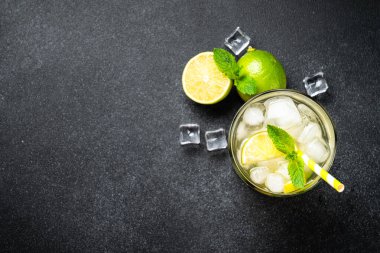 Siyah arka planda rom, limon, nane ve buzlu mojito. Geleneksel yaz içeceği. Kopyalama alanı olan düz.