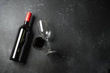Siyah arka planda şarap şişesi ve şarap kadehi. Düz görünüm.