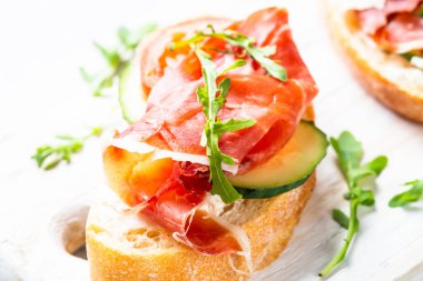 Aperatif crostini, krem peynirli sandviç, prosciutto, salatalık ve roka..