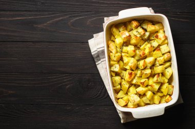 Koyu kırsal masada kekikli fırında patates. Vejetaryen yemeği. Kopyalama alanı olan üst görünüm.