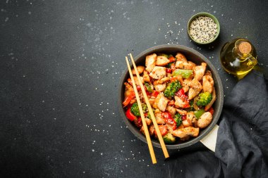 Sebzeli tavuk kızartması ve siyah arka planda susam. Kopyalama alanı olan üst görünüm.