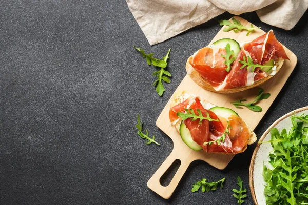 Krem peynirli sandviç, jambon, salatalık ve roka. Metin için boşluk olan üst görünüm.