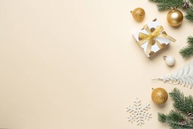 Noel süslemeleri, hediye kutusu, balolar ve köknar ağacı dalları. Renk arkaplanı üzerindeki en üst görüntü ve tasarım alanı.