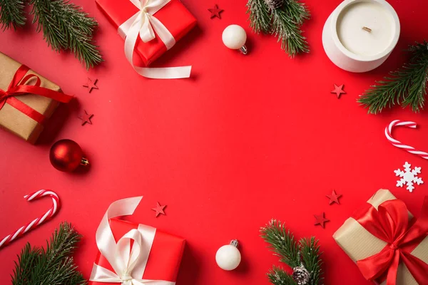 Hediyeler ve dekorasyonlarla Noel kompozisyonu. Kırmızı arkaplanda düz resim yatıyordu.
