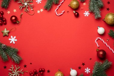 Noel arkaplanı kırmızıda yatıyordu. Noel süsleri, köknar ağacı ve hediyeler. Kopyalama alanı olan düz resim.