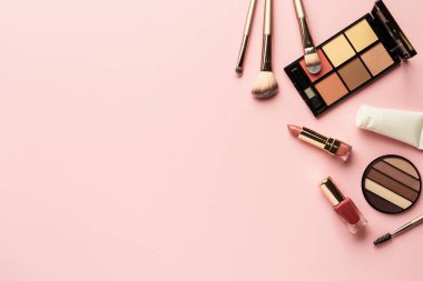 Pembenin arka planını hazırla. Göz farı, fosforlu kalem, krem, ruj ve kozmetik fırçalar..