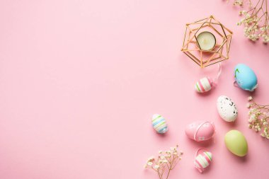 Paskalya yumurtaları pembe arka planda. Renkli yumurtalar, çiçekler. Kopyalama alanı olan düz.