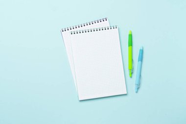 Mavi arka planda not defteri ve kalem. Kopyalama alanı olan düz.