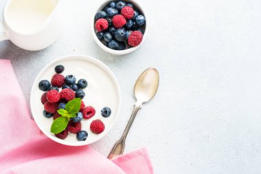 Beyaz arka planda taze böğürtlenli yoğurt. Sağlıklı atıştırmalıklar ya da kahvaltı. Tasarım için alanı olan üst görünüm.