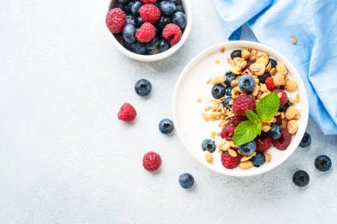 Beyaz masada taze böğürtlenli yoğurt ve tahıl gevreği. Sağlıklı kahvaltı. Kopyalama alanı olan üst görünüm.