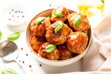 Beyaz masanın üstünde domates soslu köfte. Metin için boşluk ile kapat.