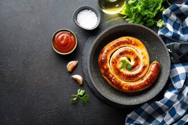 Sosis, ızgara et, domates soslu domuz sucuğu. Koyu mutfak masasının üstü..