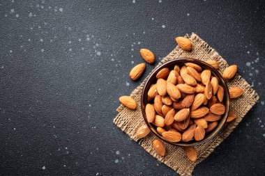 Siyah arka planda fındıklar kasede. Üst görünüm.