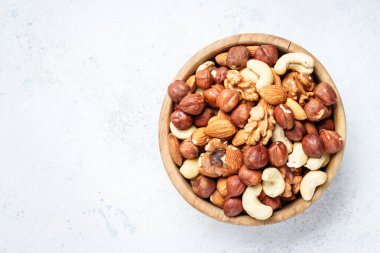 Beyaz arka planda fındık çeşitleri. Badem, fındık, ahşap kasede kaju. Üst görünüm